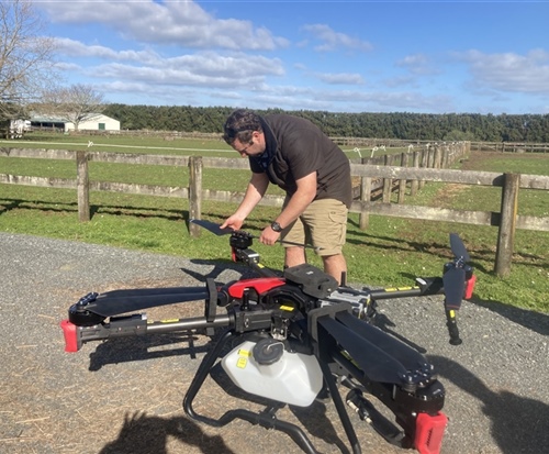 operator perfroming preflight checks on large 50kg payload drone