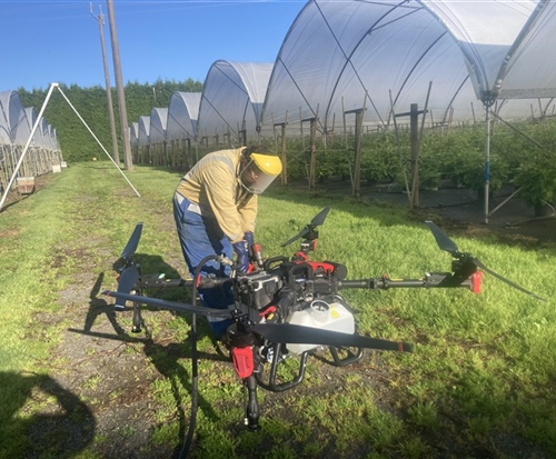 refueling drone in horticultural setting fruit trees in background