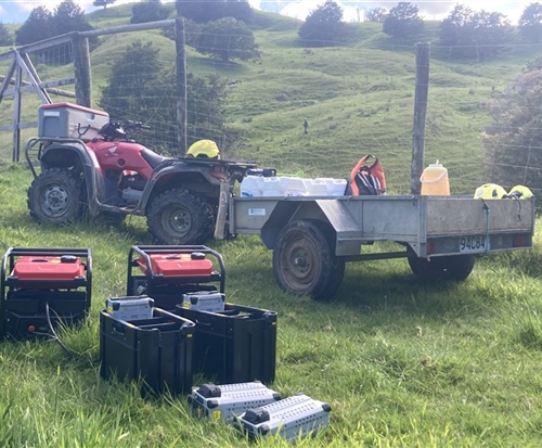 Quad bike and trailer on back counrty farm ready to deploy herbicide