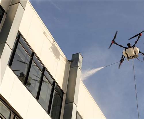 Drone water blasting of a large commercial building for an instant clean