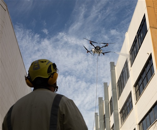 Drone water blasting of a large commercial building for an instant clean